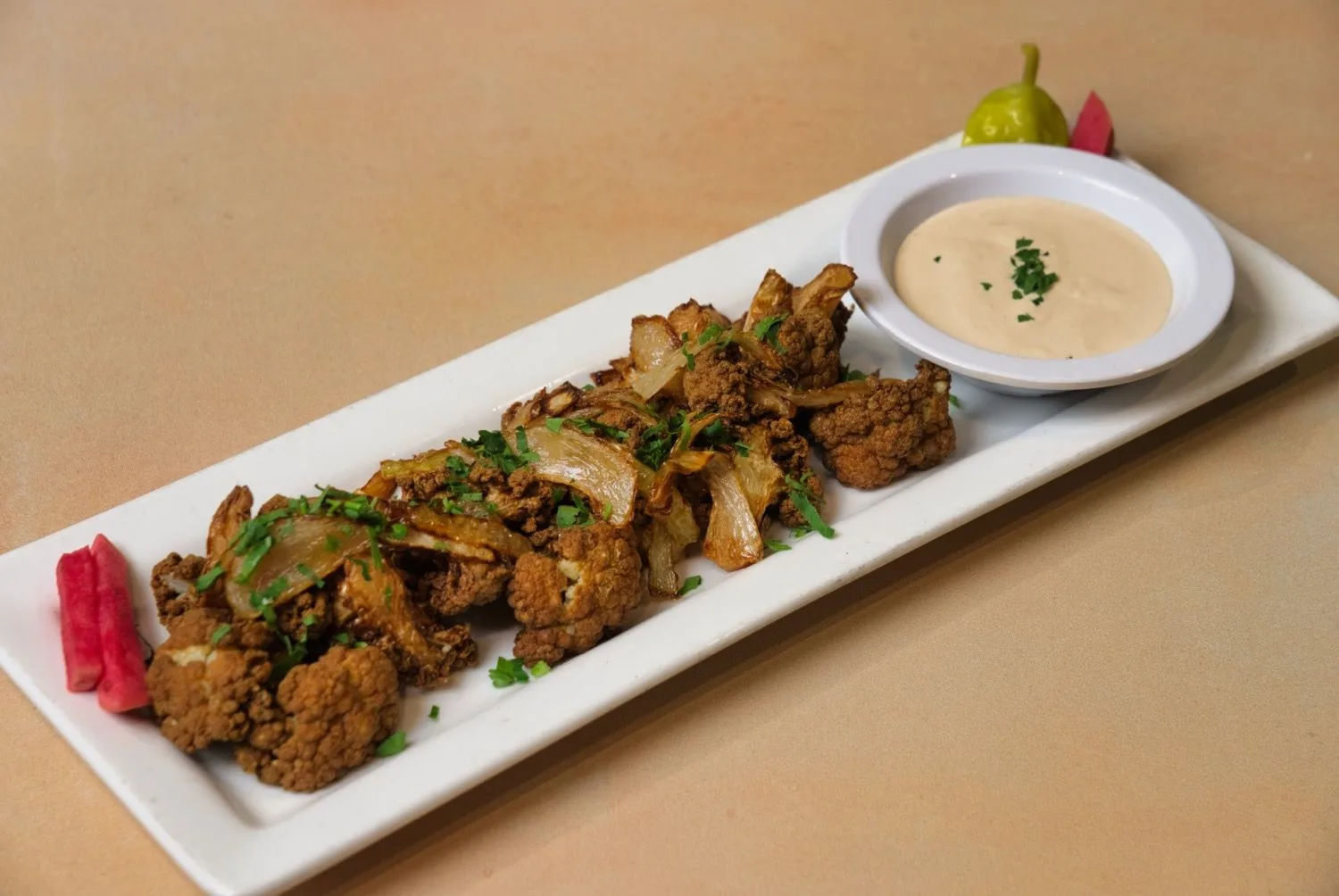 Fried cauliflower with caramelized onions and tahini sauce at Phoenician Garden in Fresno