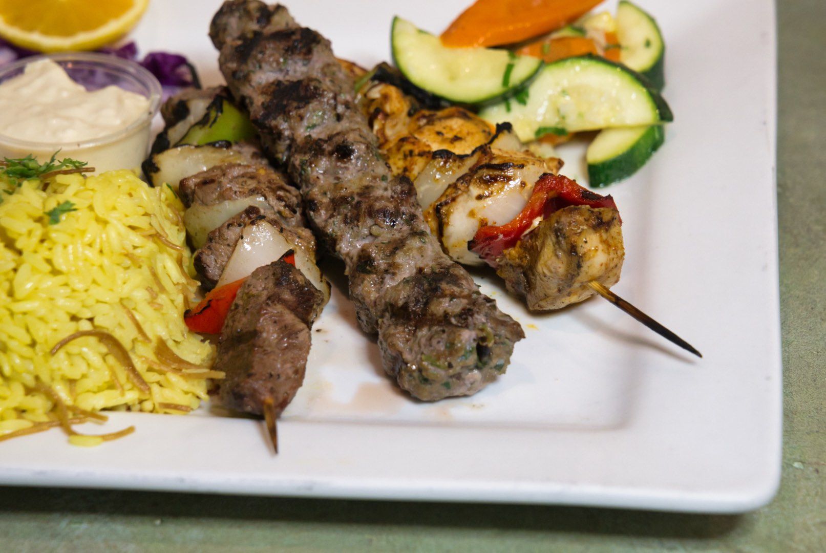 Combo kebobs family feast with beef and chicken skewers, rice, and vegetables